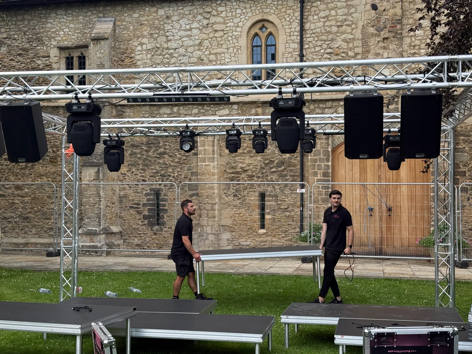 Bucks AV crew building the stage beneath the sound and lighting truss at the Cambridge University festival
