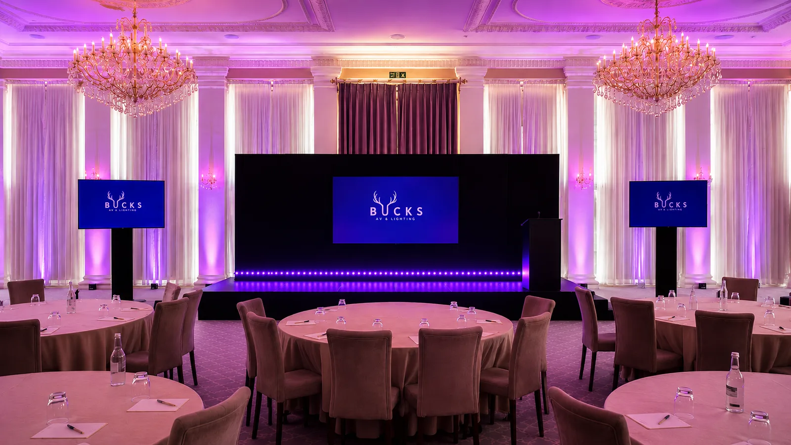 Bucks AV presentation screens, staging and purple room lighting set up for an event